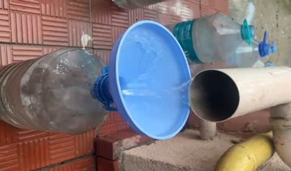 Yağmur sularını pet şişe ve bidonlara doldurarak biriktiriyor